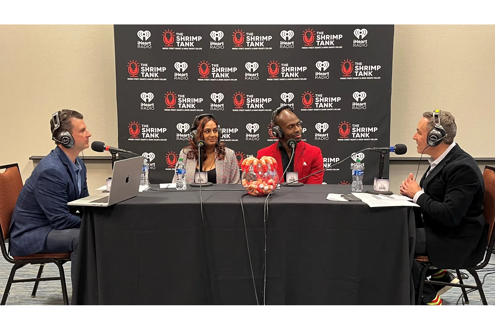 a group of people sitting at a table with microphones