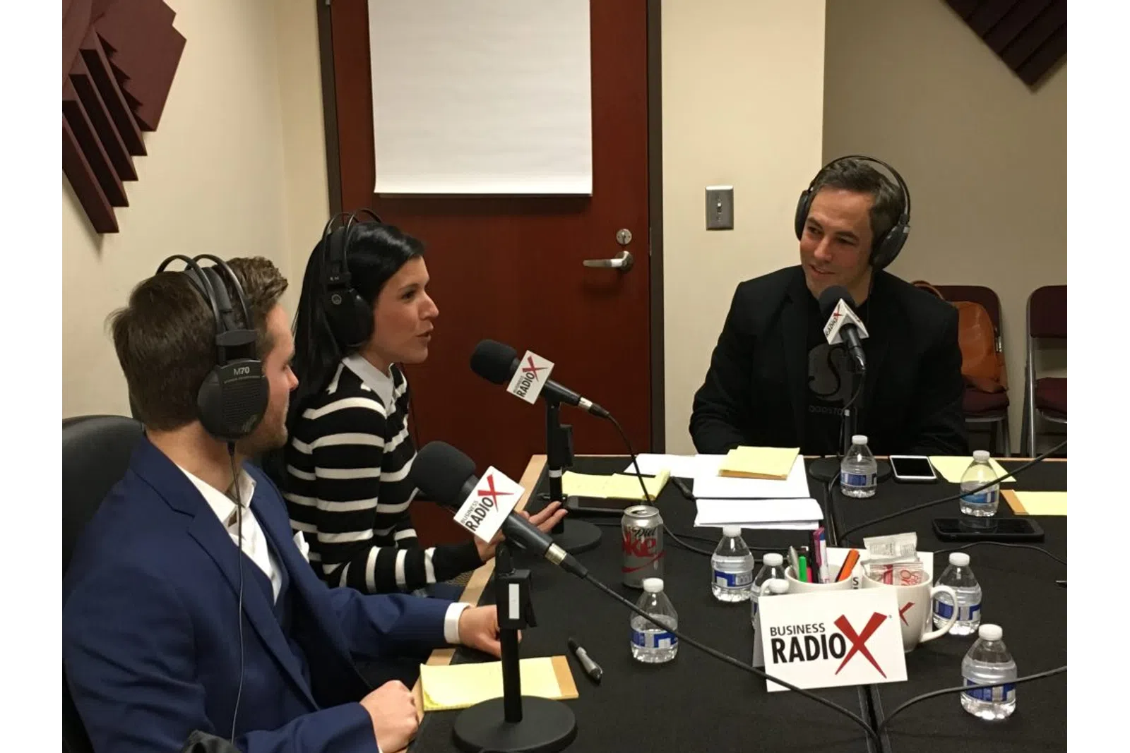a group of people sitting at a table with microphones