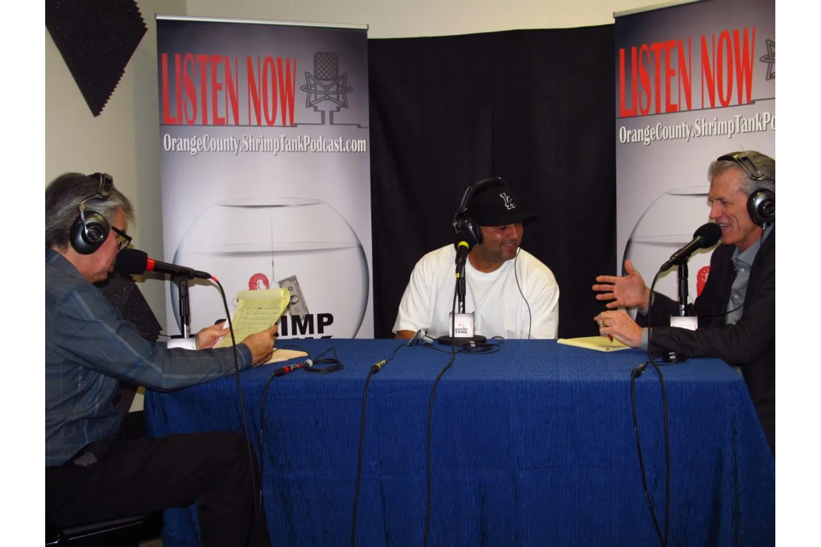 a group of people sitting at a table with microphones