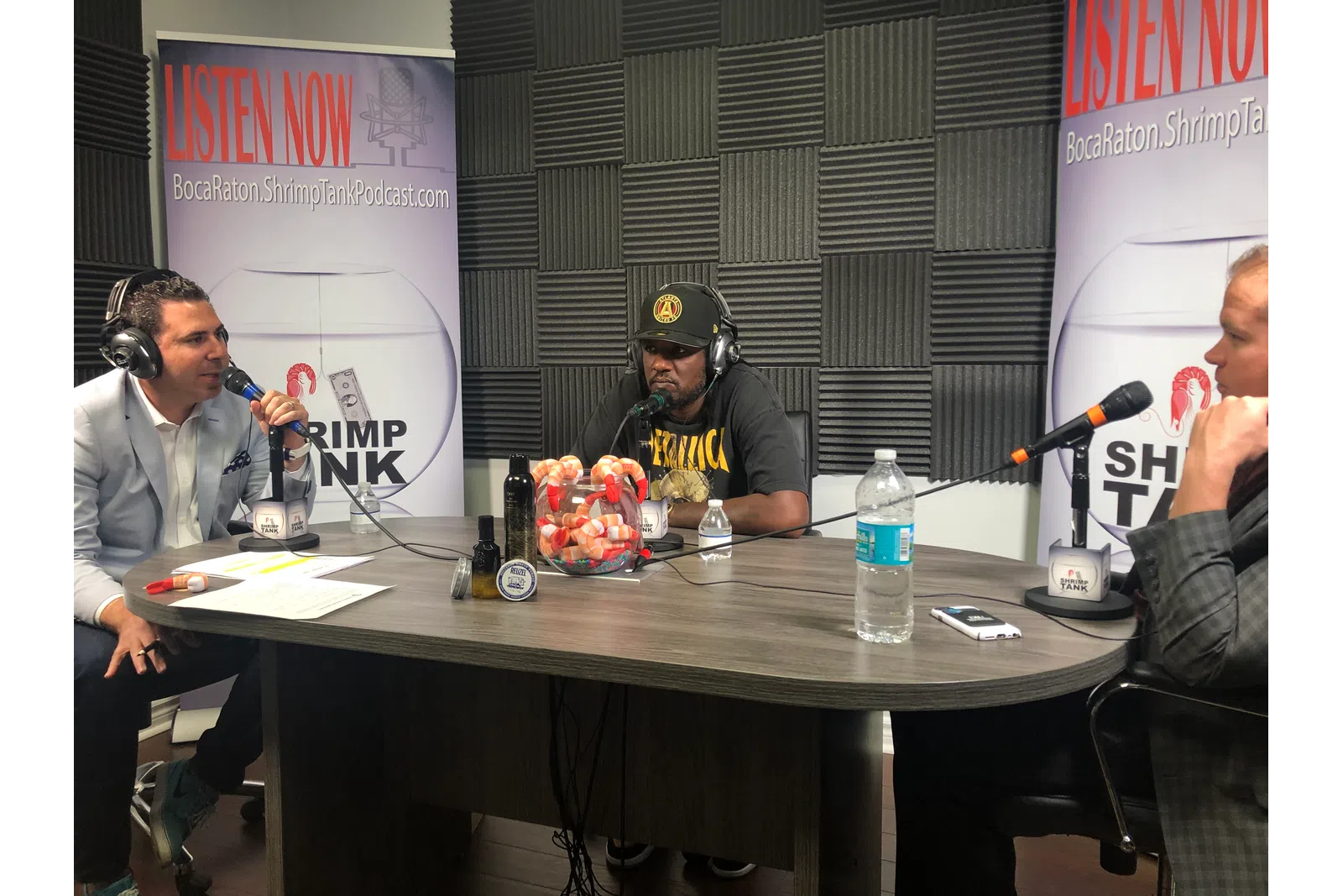 a group of people sitting at a table with microphones