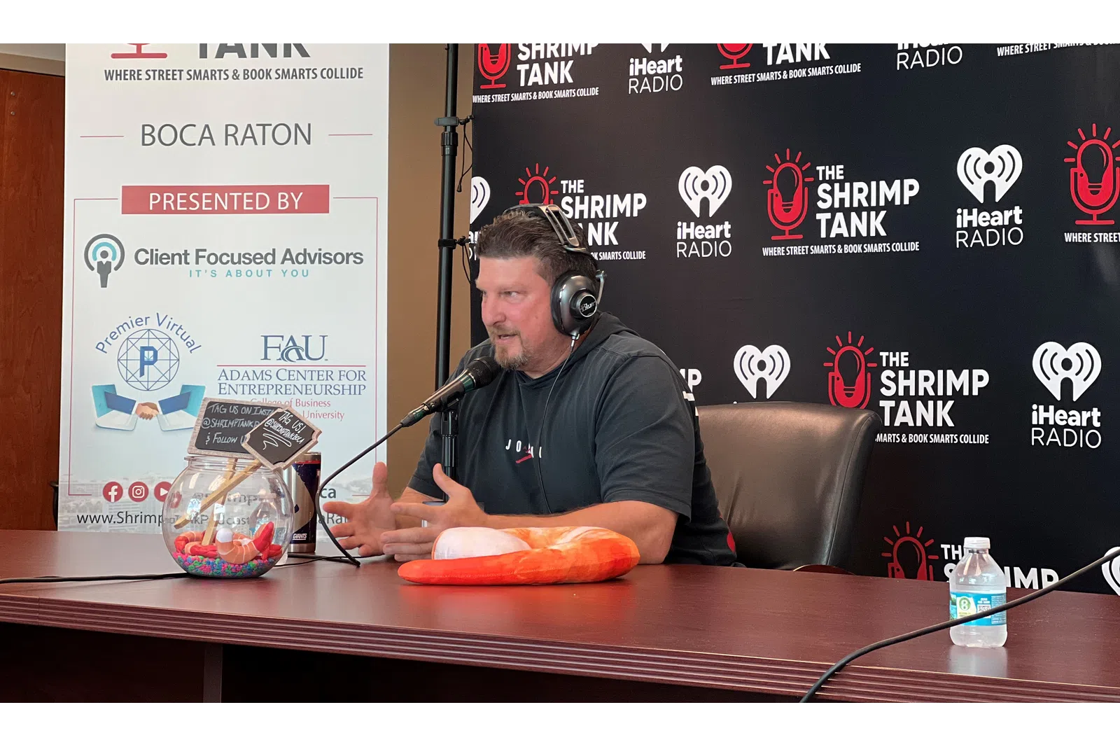 a man wearing headphones and sitting at a table with a microphone