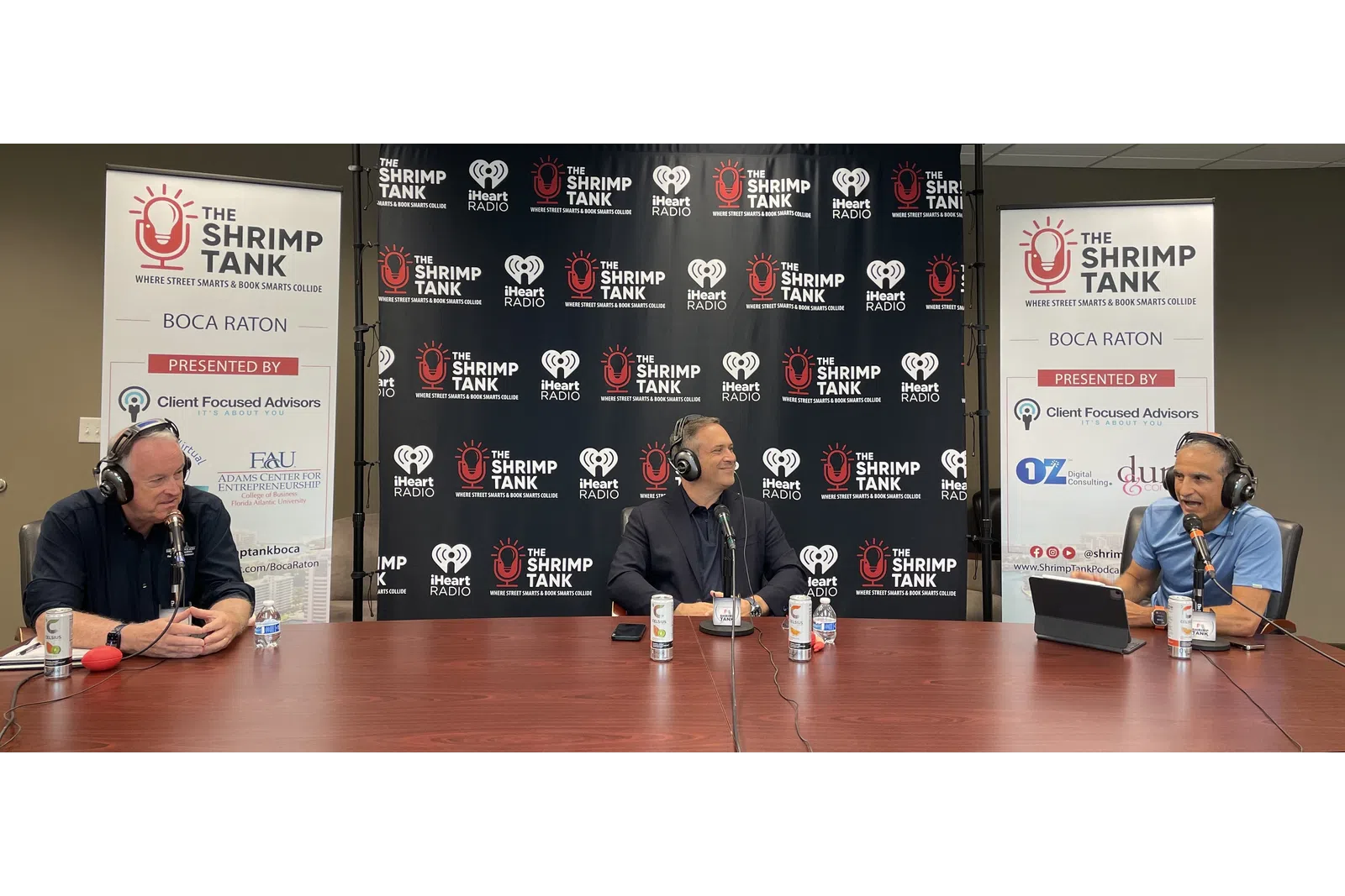 a group of people sitting at a table with microphones