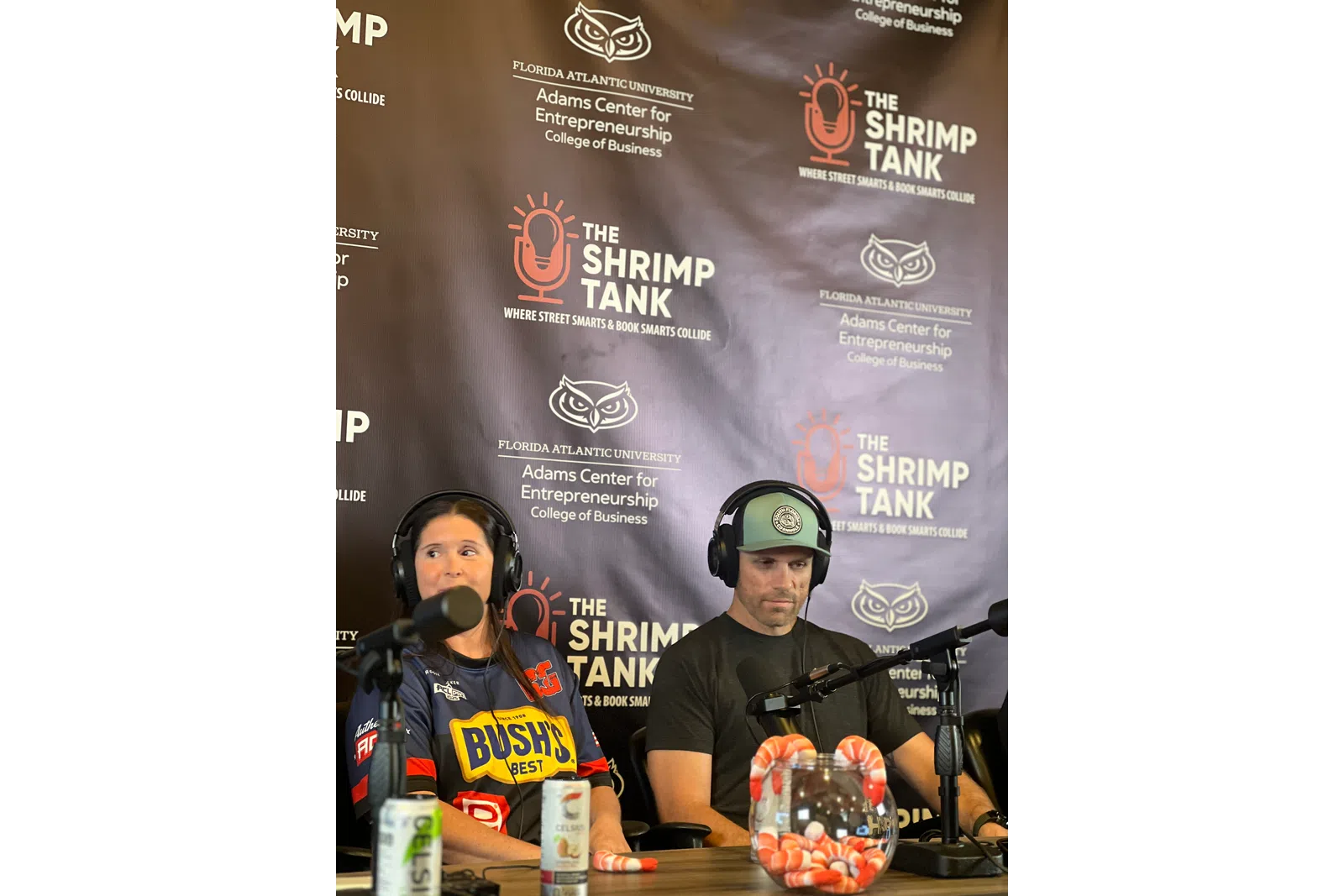 Hosts of The Shrimp Tank podcast discuss entrepreneurship with microphones in a studio setting.