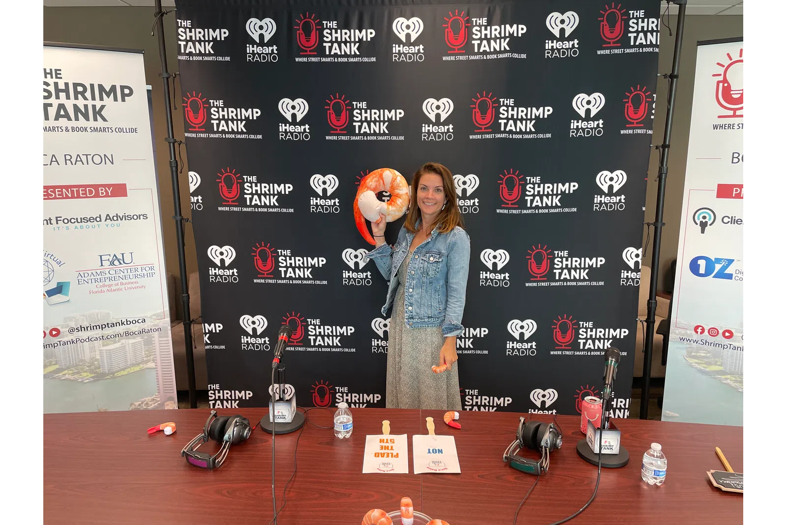 a person standing next to a table with a stuffed animal