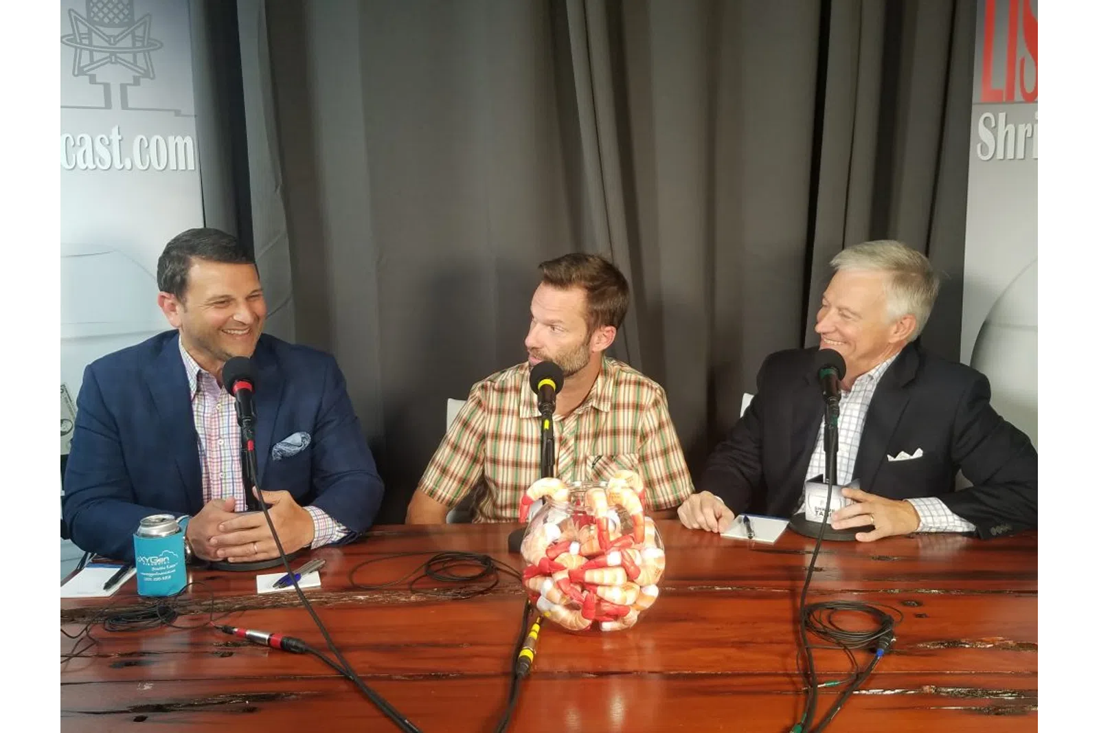 a group of men sitting at a table with microphones