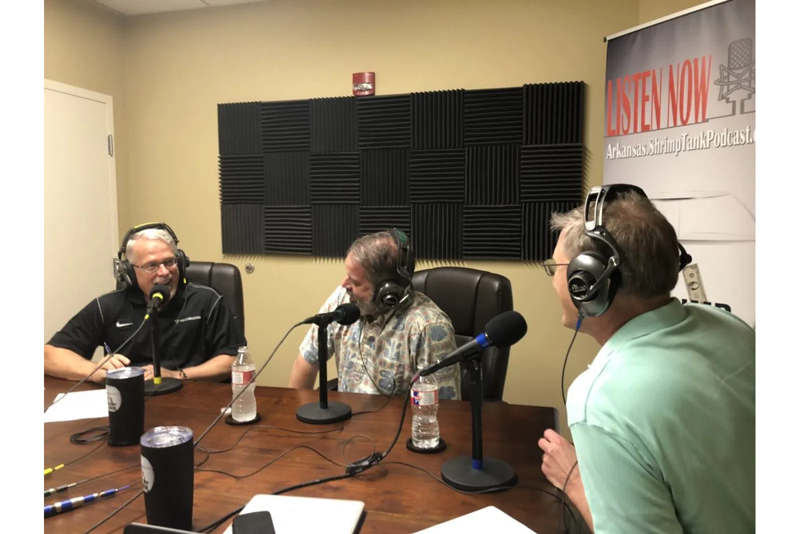 a group of men sitting at a table with microphones