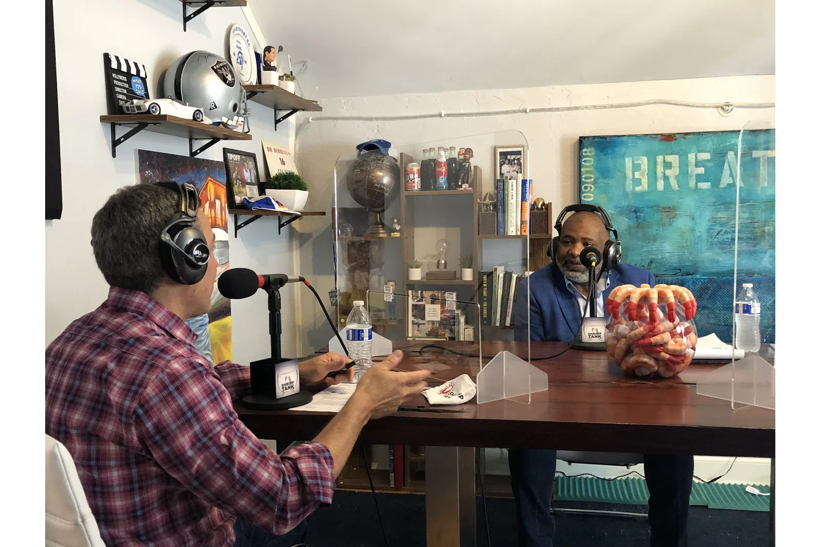 a couple of men wearing headphones and sitting at a table