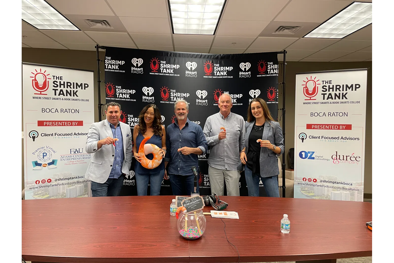 a group of people standing in front of a table with a sign
