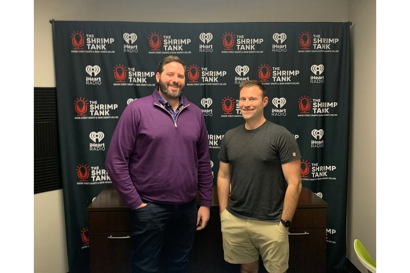 a couple of men standing in front of a blackboard