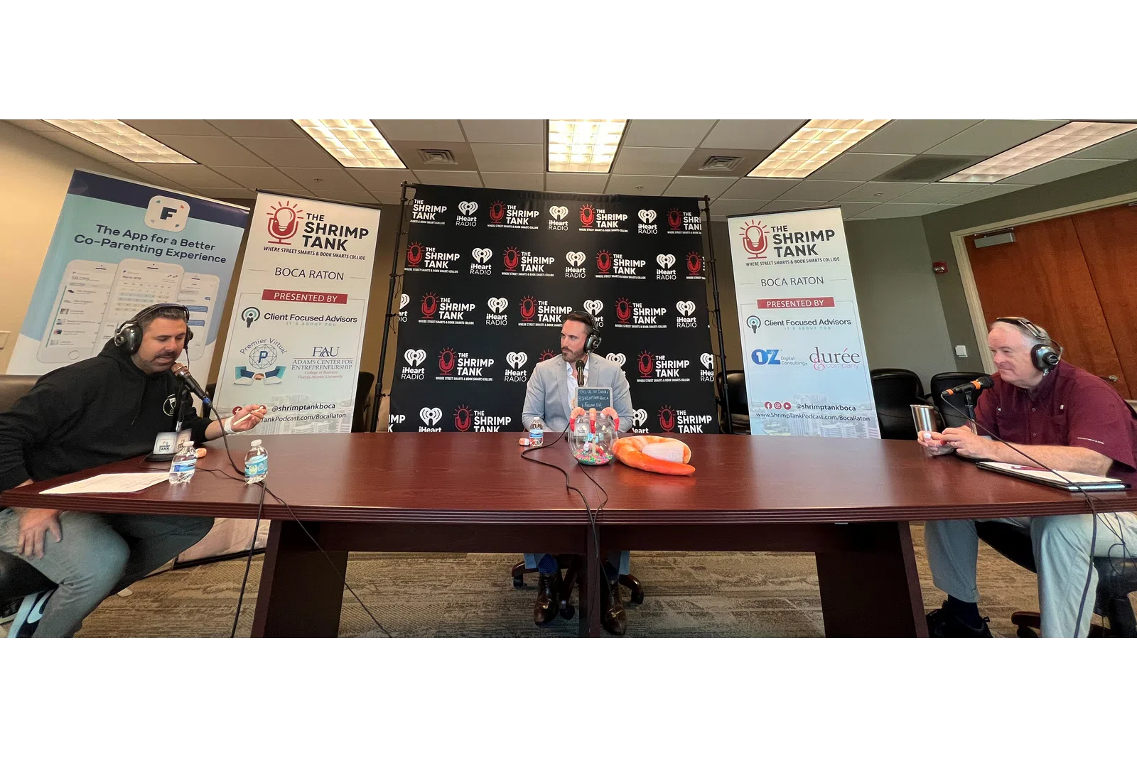 a group of people sitting at a table with microphones