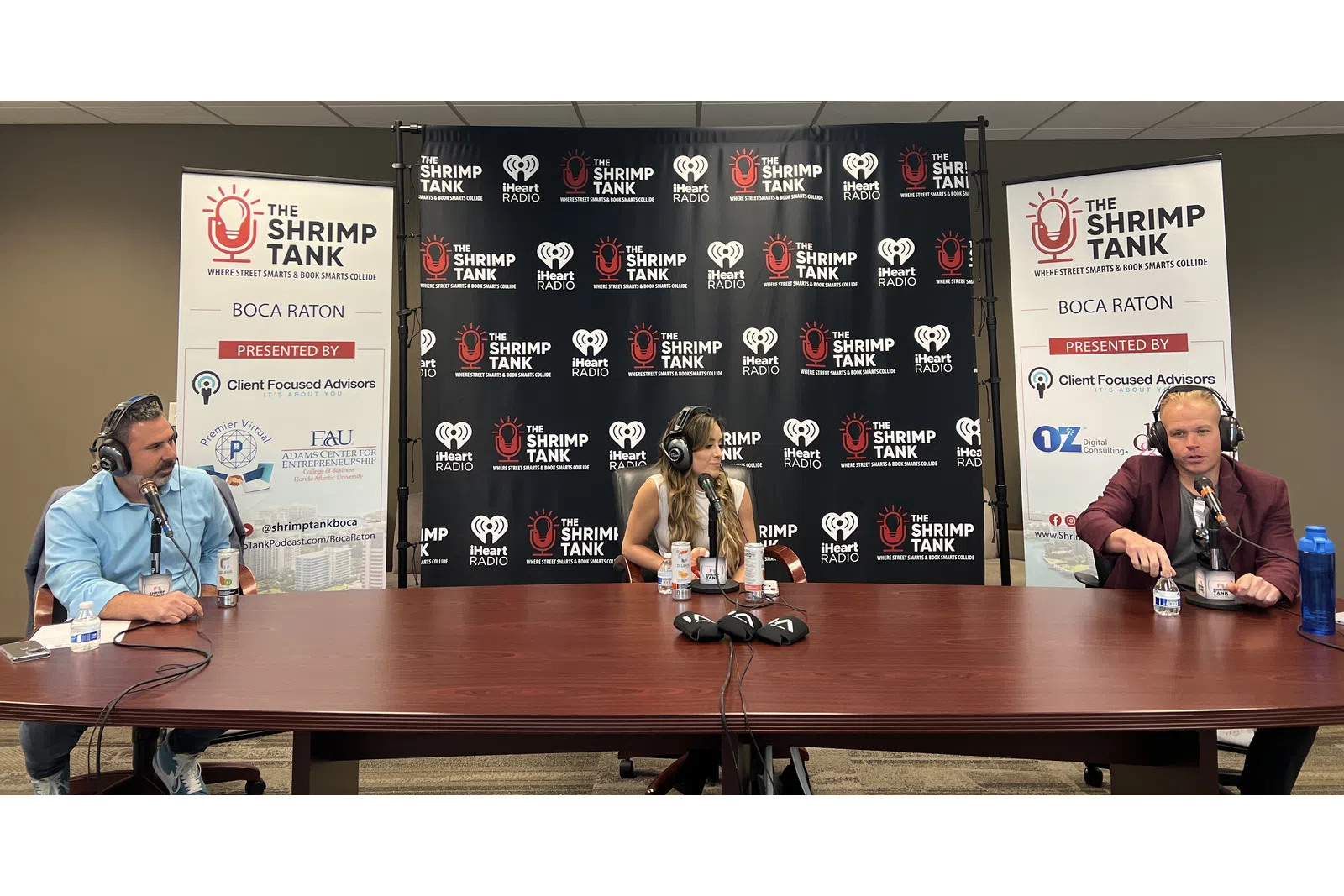 a group of people sitting at a table with microphones