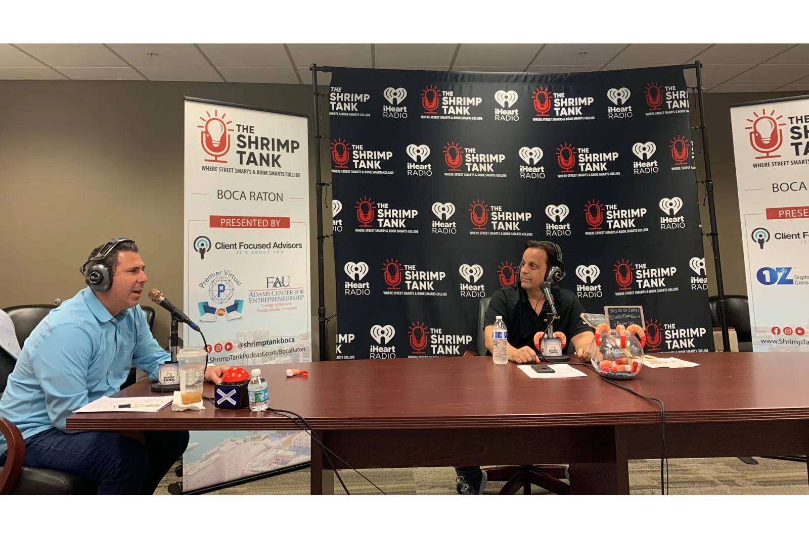 a man and woman sitting at a table with microphones
