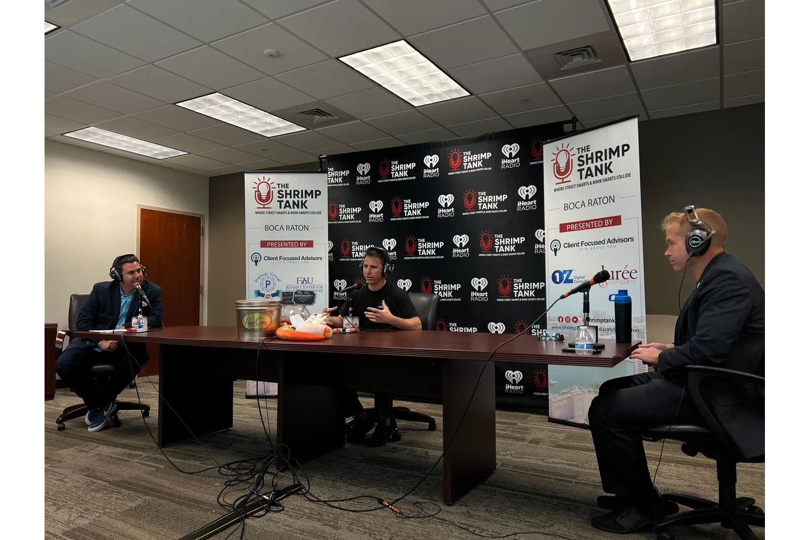 a group of people sitting at a table with microphones and a sign