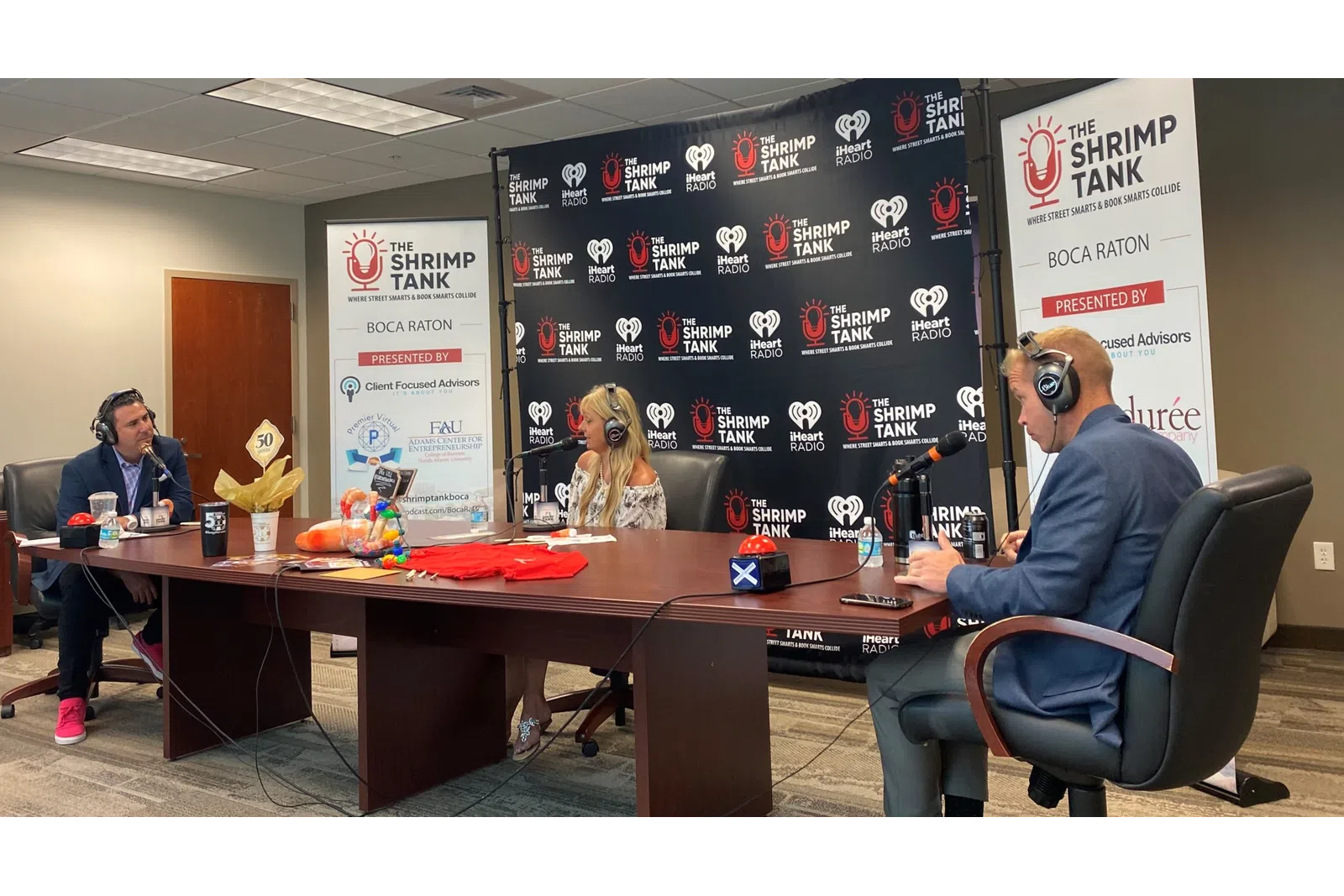 a group of people sitting at a table with microphones