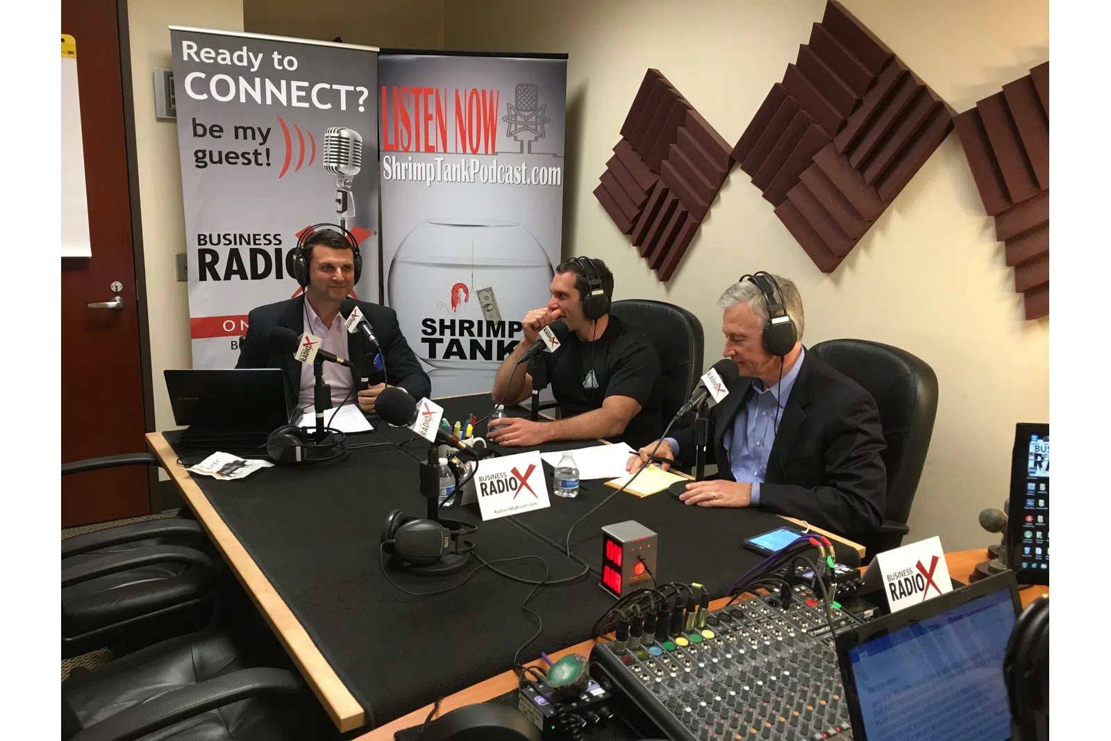 a group of people sitting at a table with microphones