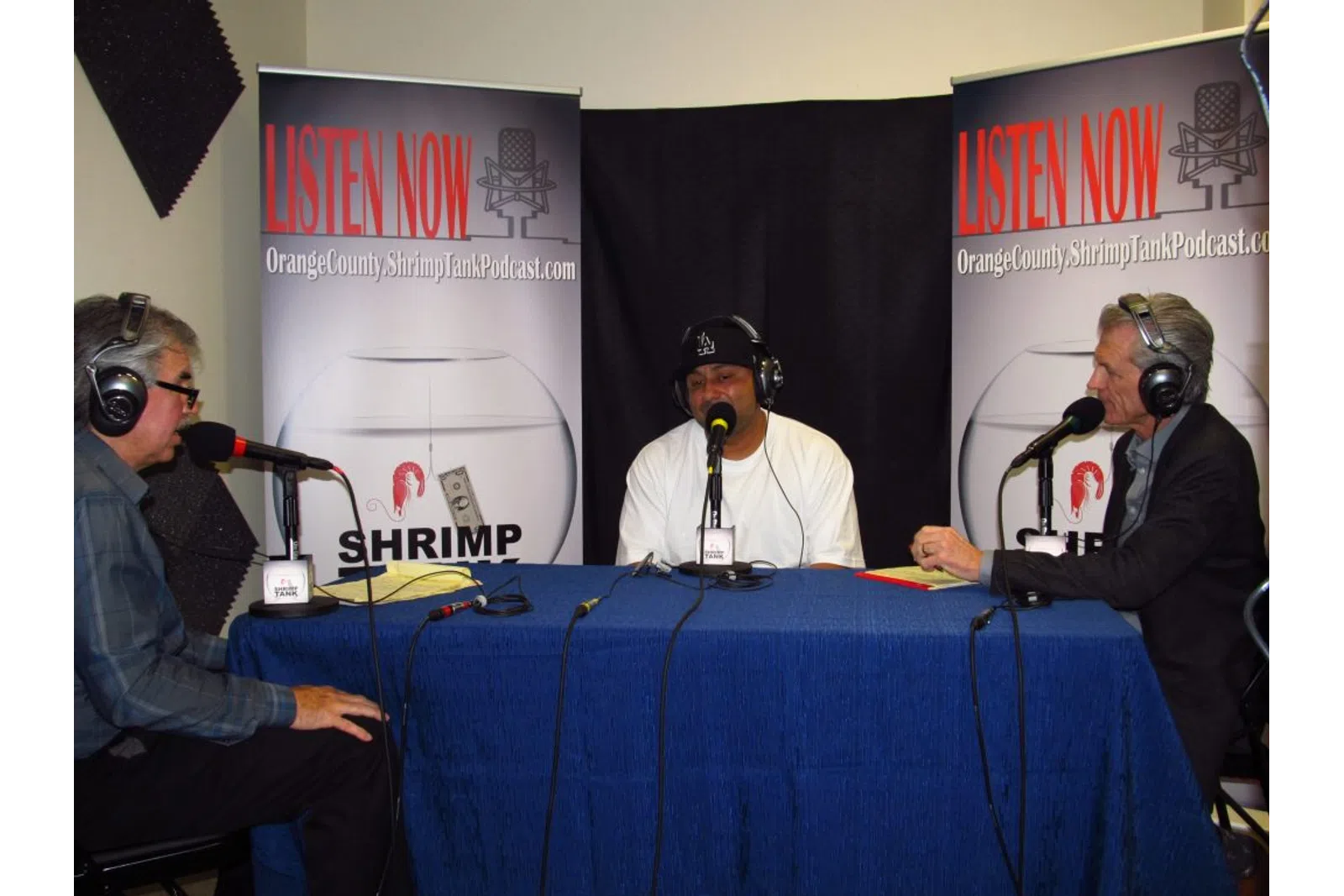a group of people sitting at a table with microphones