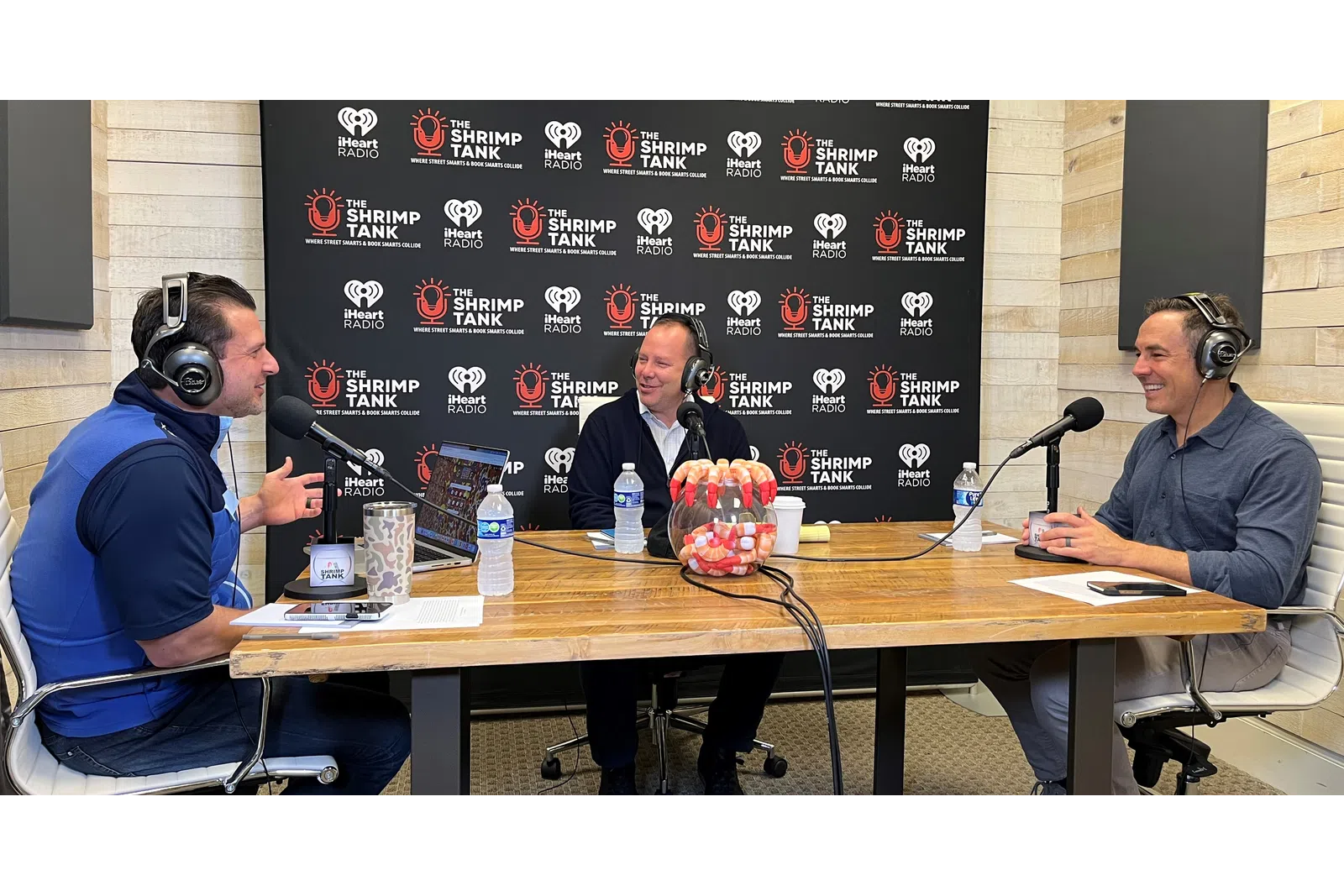 a group of people sitting at a table with microphones