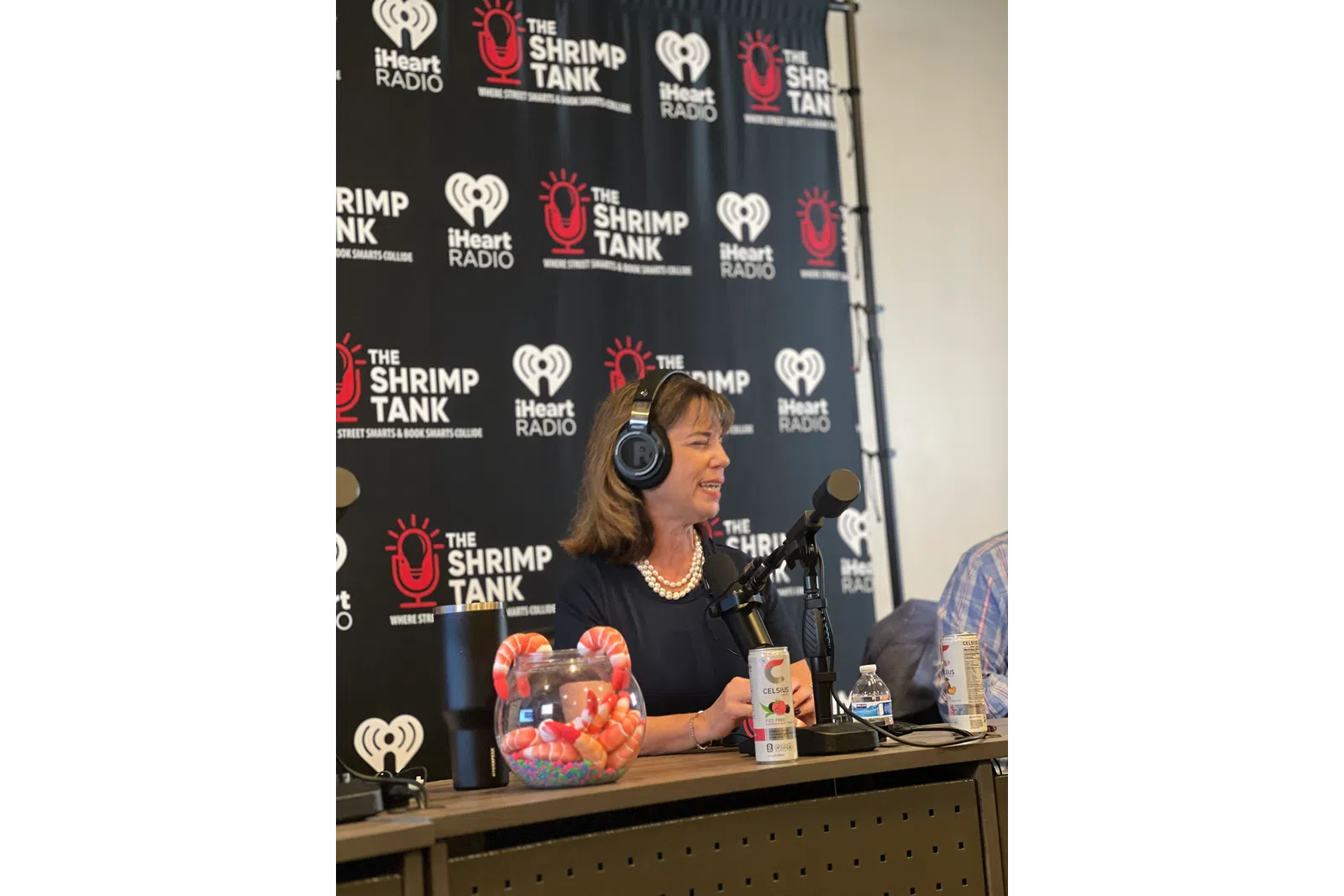 a person wearing headphones and sitting at a table with a microphone