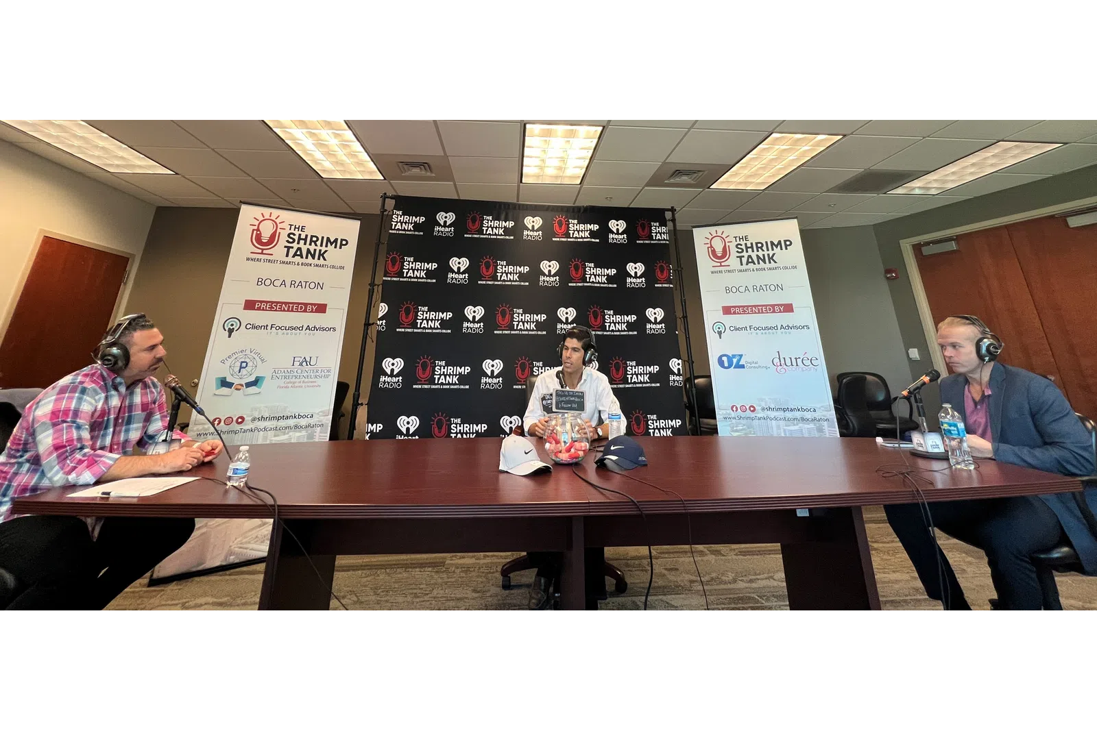 a group of people sitting at a table with microphones