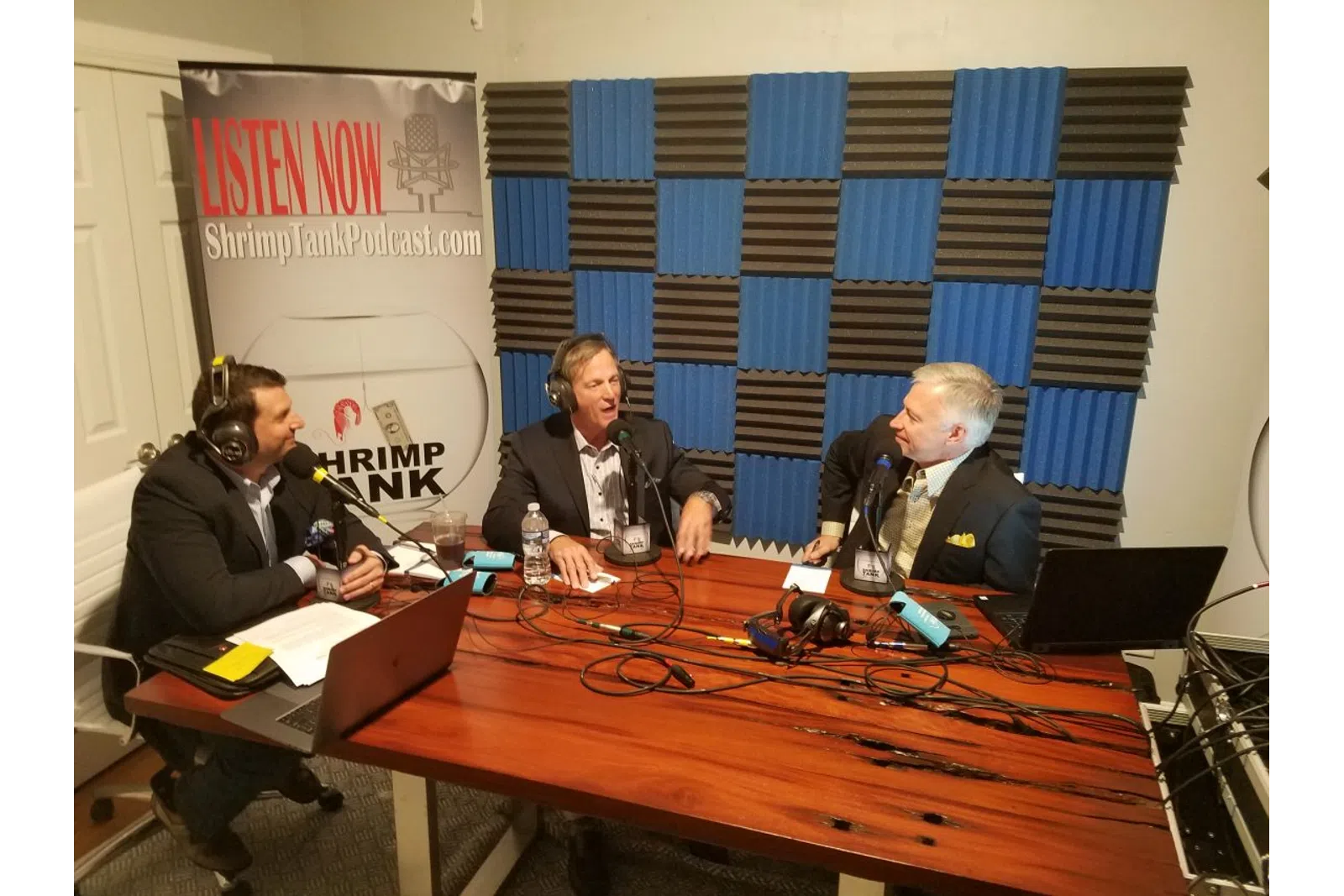 a group of people sitting at a table with microphones