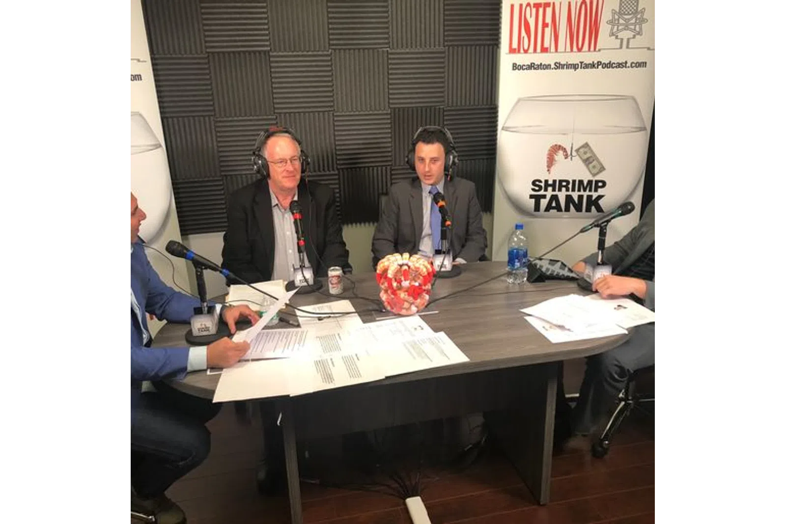 a group of people sitting at a table with microphones