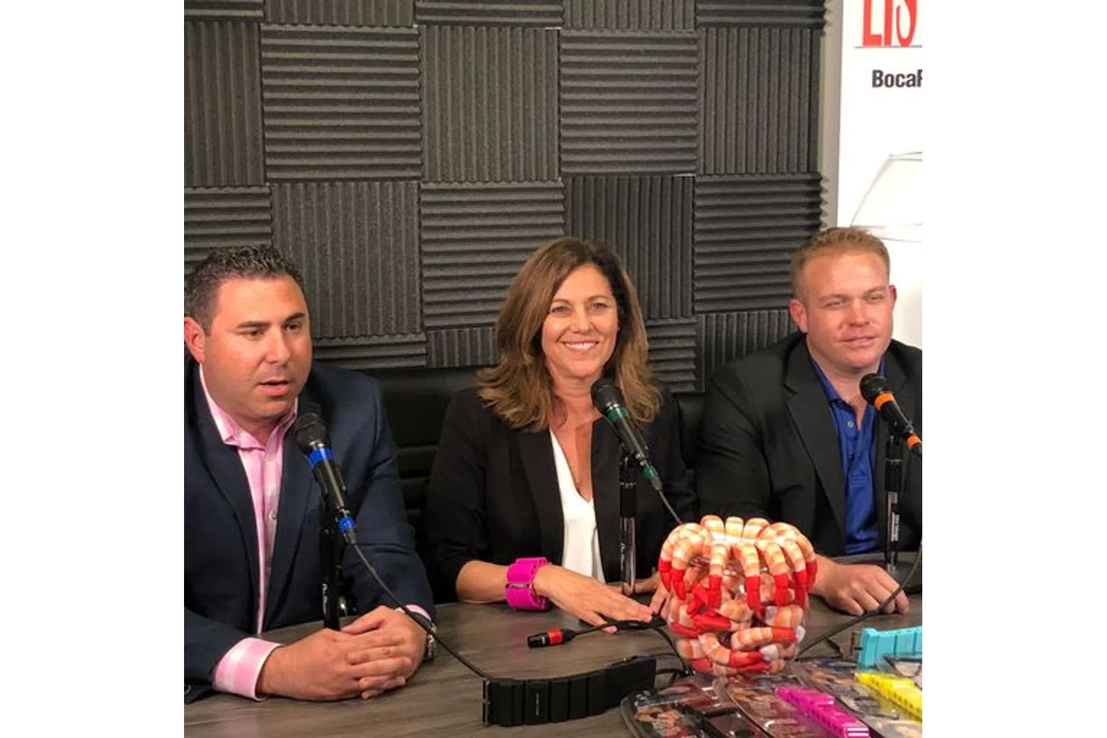 a group of people sitting at a table with microphones