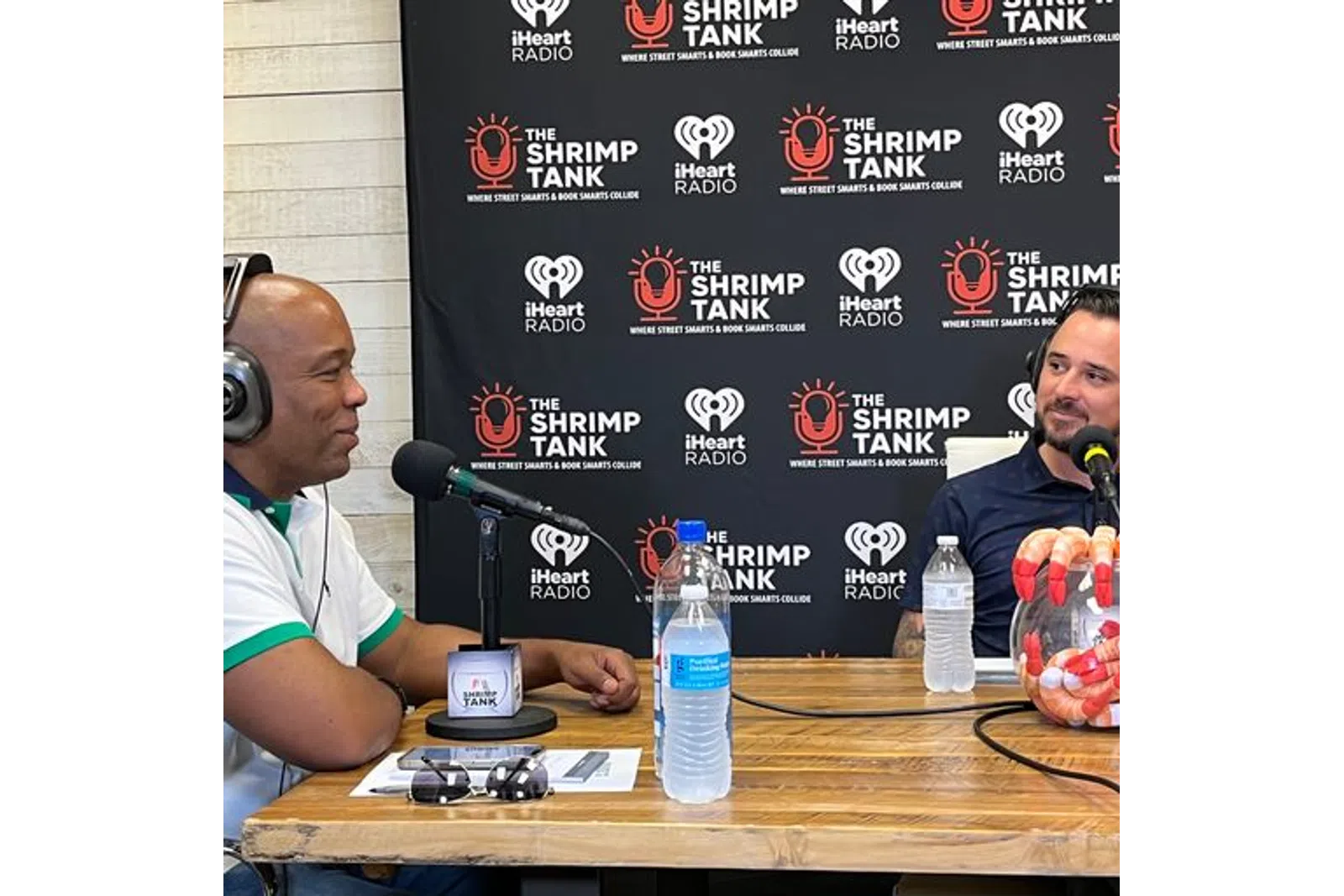 a person wearing headphones sitting at a table with a microphone