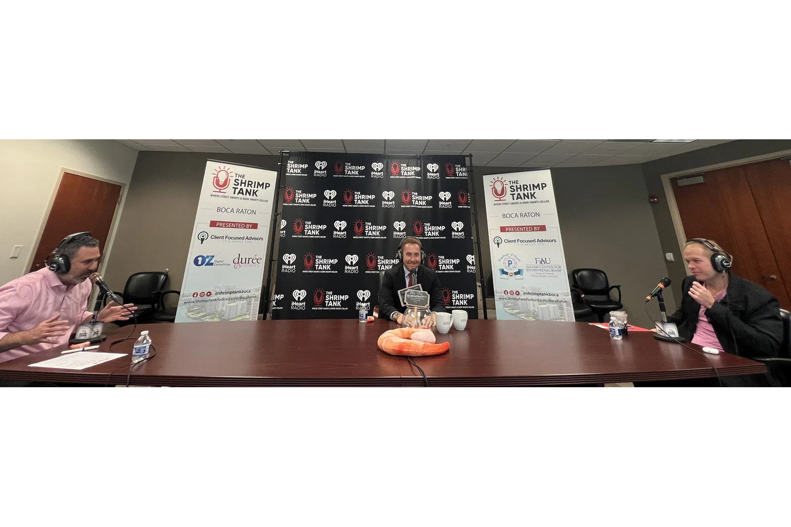 a group of people sitting at a table with microphones