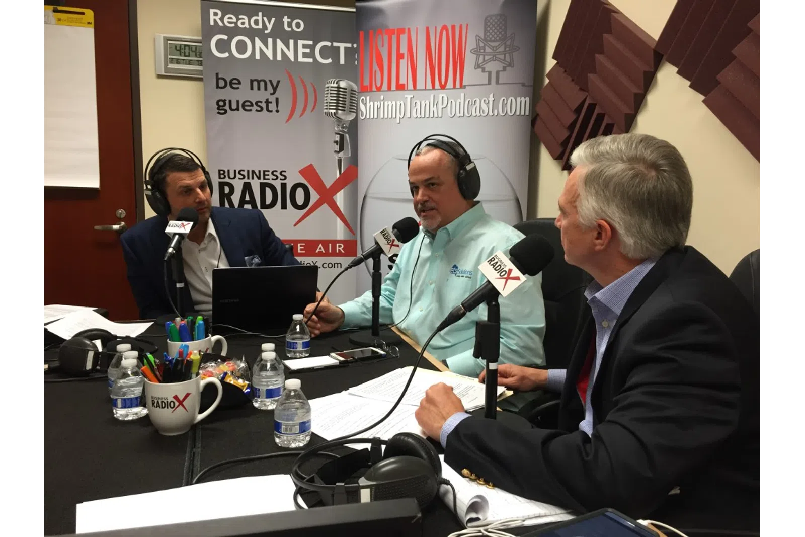 a group of people sitting at a table with microphones