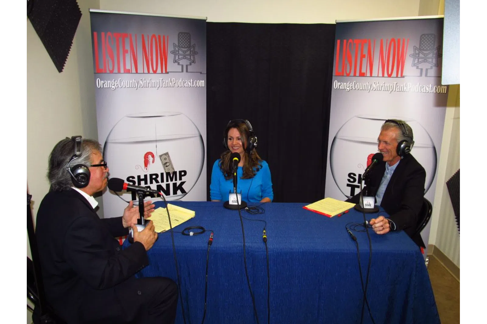a group of people sitting at a table with microphones