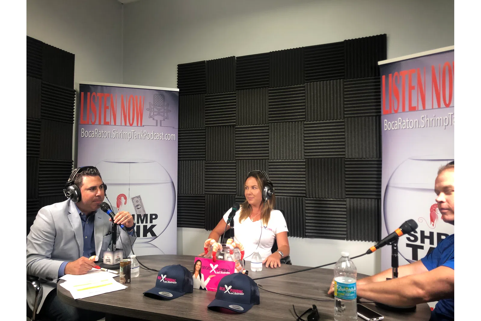 a group of people sitting at a table with microphones