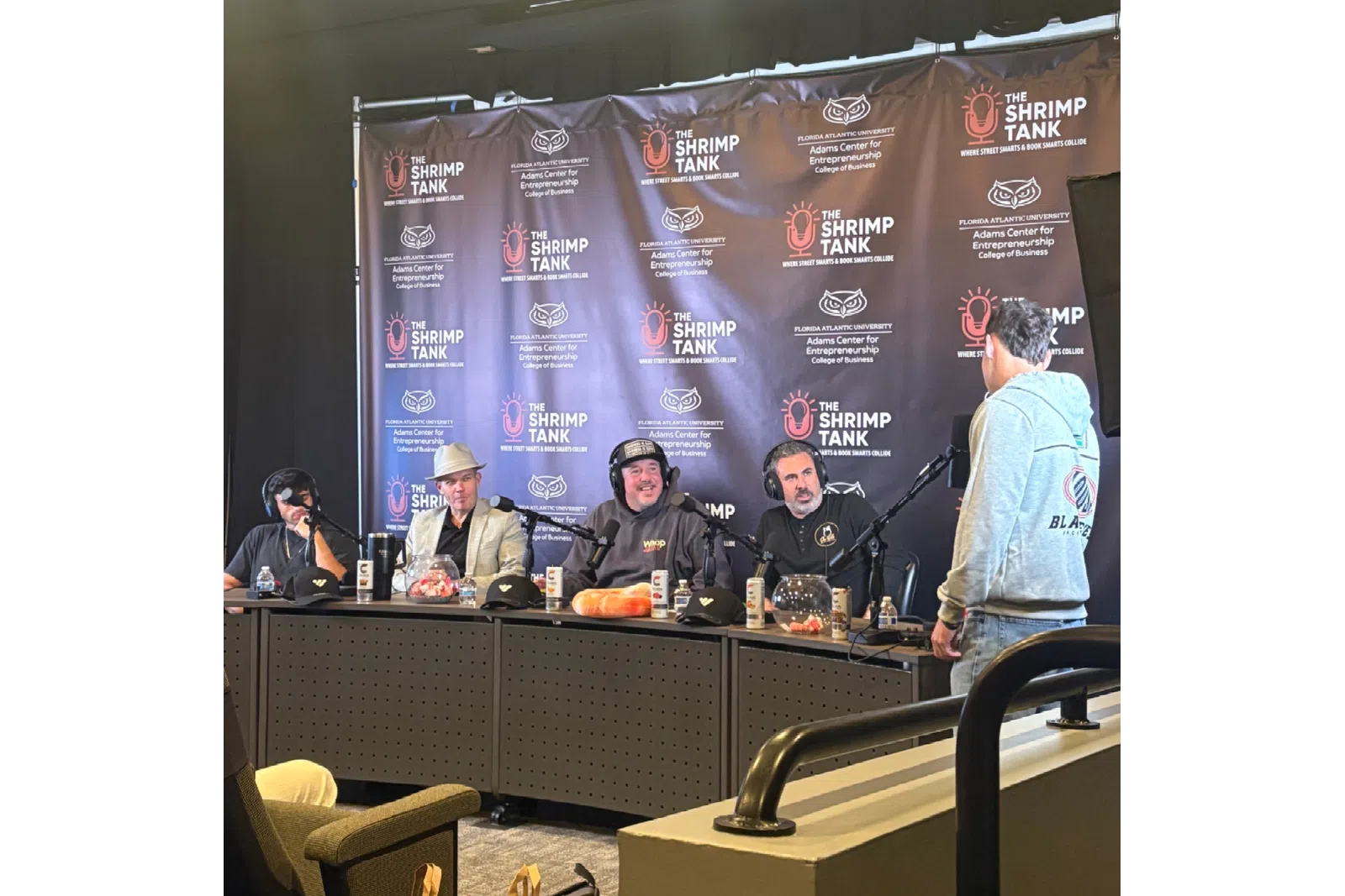 Podcast recording at The Shrimp Tank with hosts and guest at microphones in studio setting