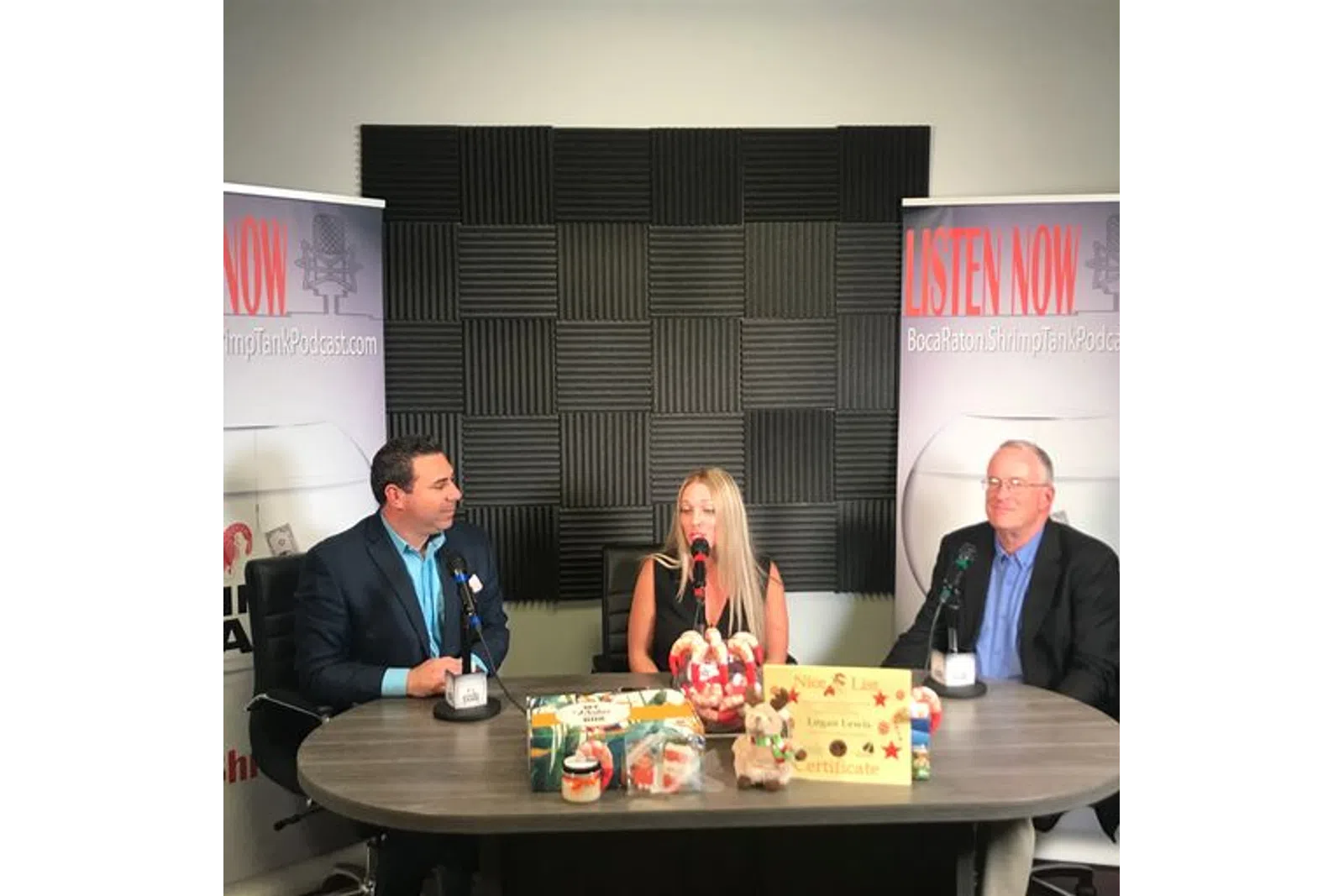 a group of people sitting at a table with microphones