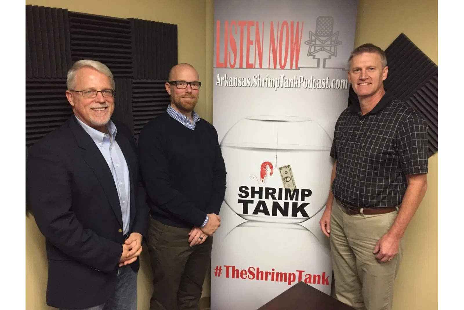 a group of men standing next to a sign