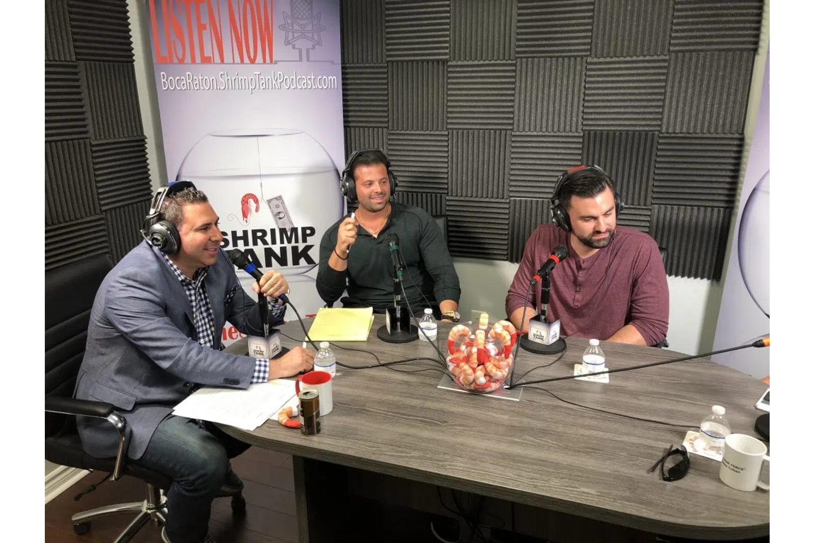 a group of men sitting at a table with microphones