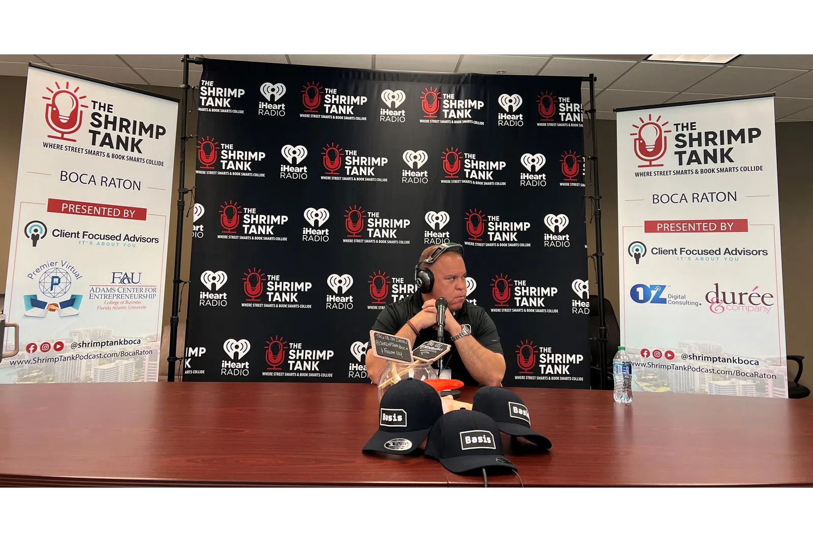 a person sitting at a desk with a microphone and headphones on