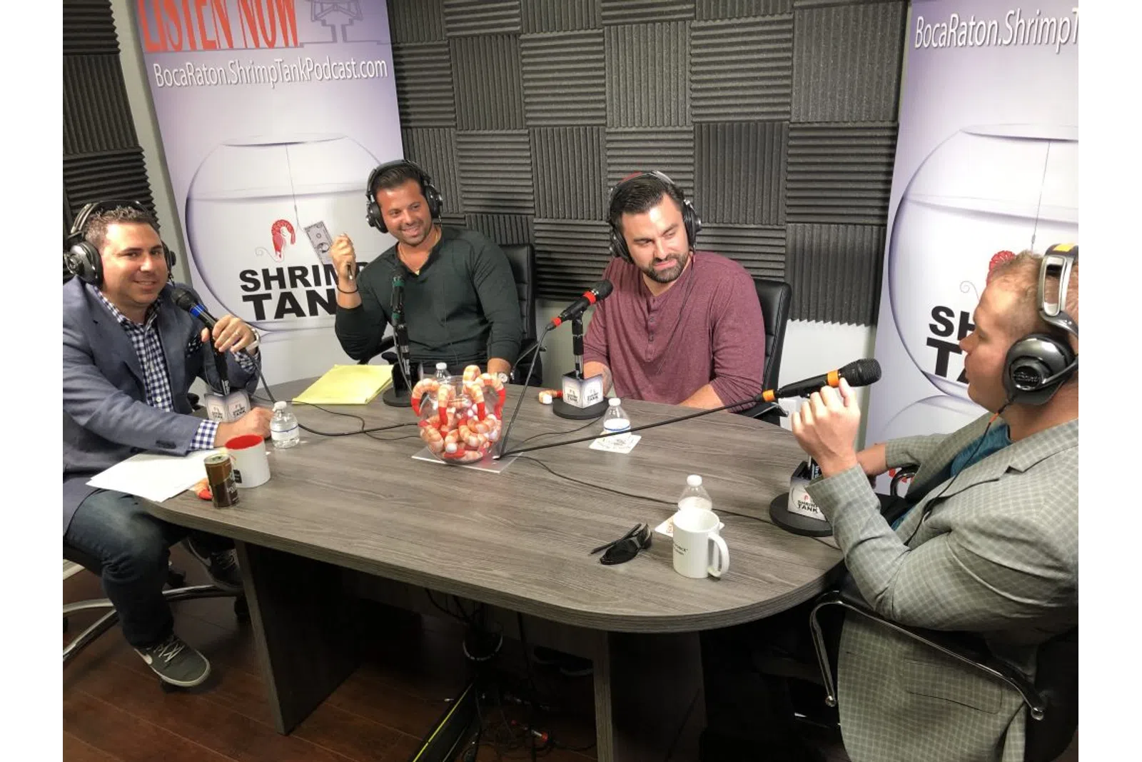 a group of men sitting around a table with microphones