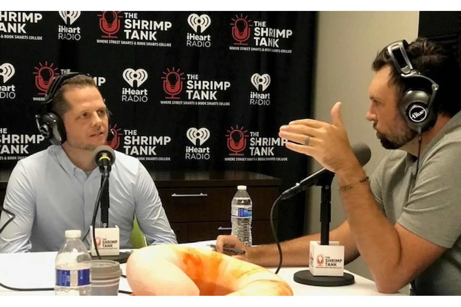 a person wearing headphones and sitting next to a person wearing a microphone