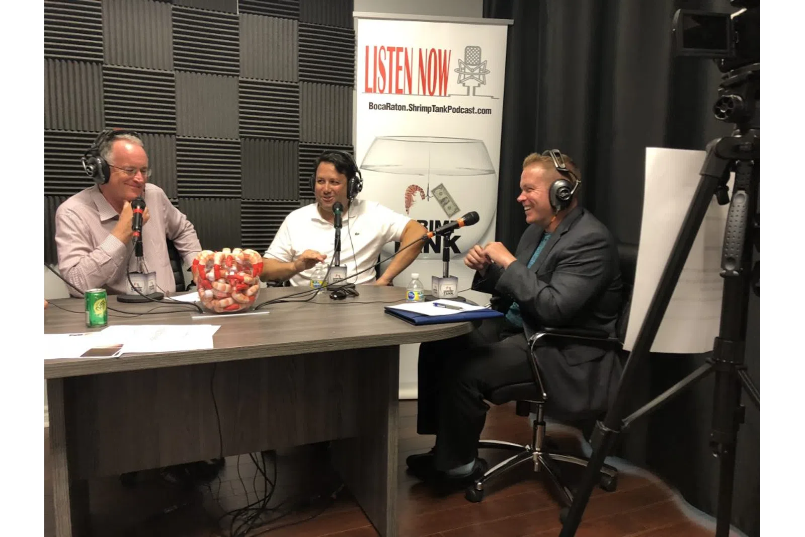 a person sitting at a table with a microphone and a person sitting at a table with a microphone