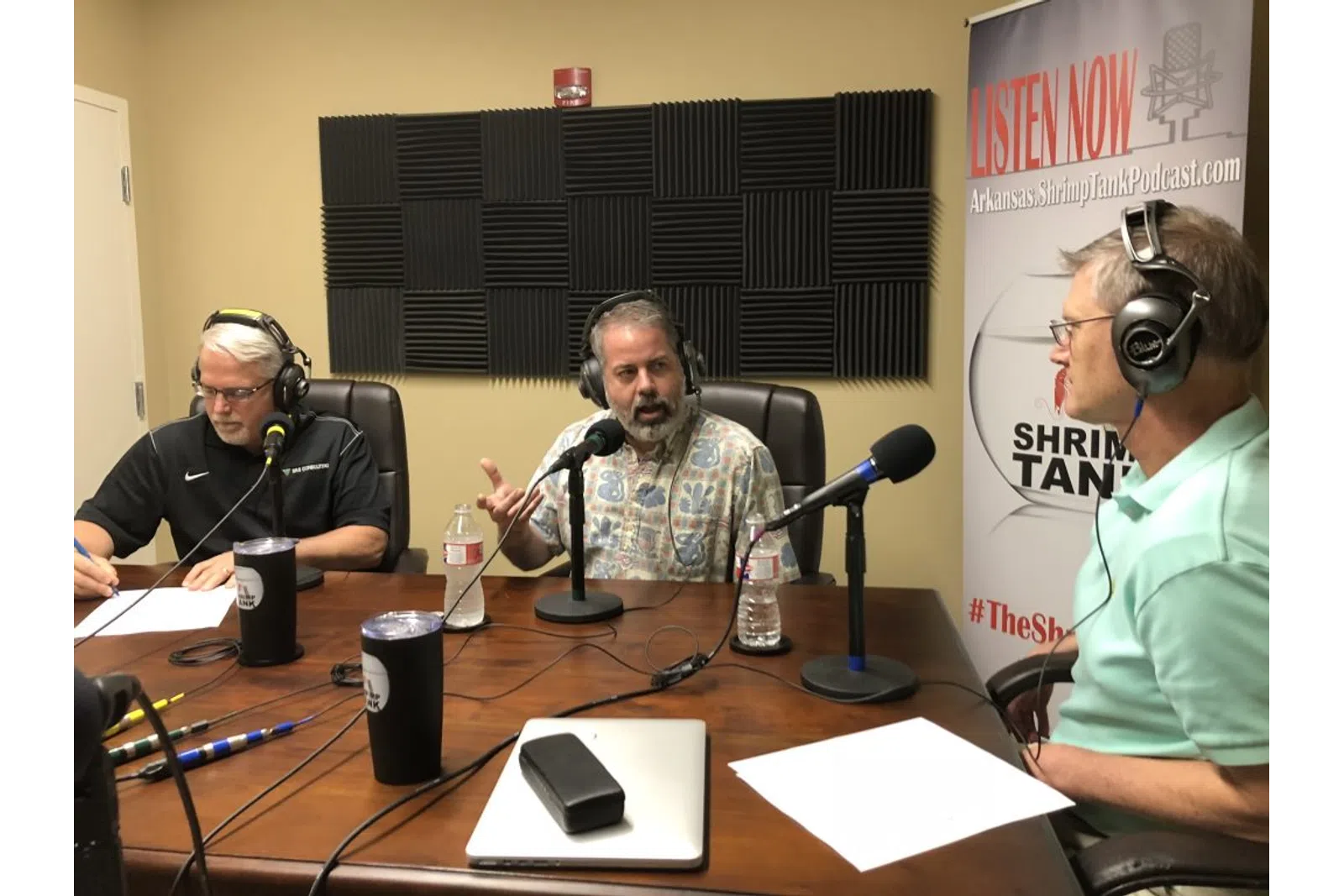 a group of people sitting at a table with microphones