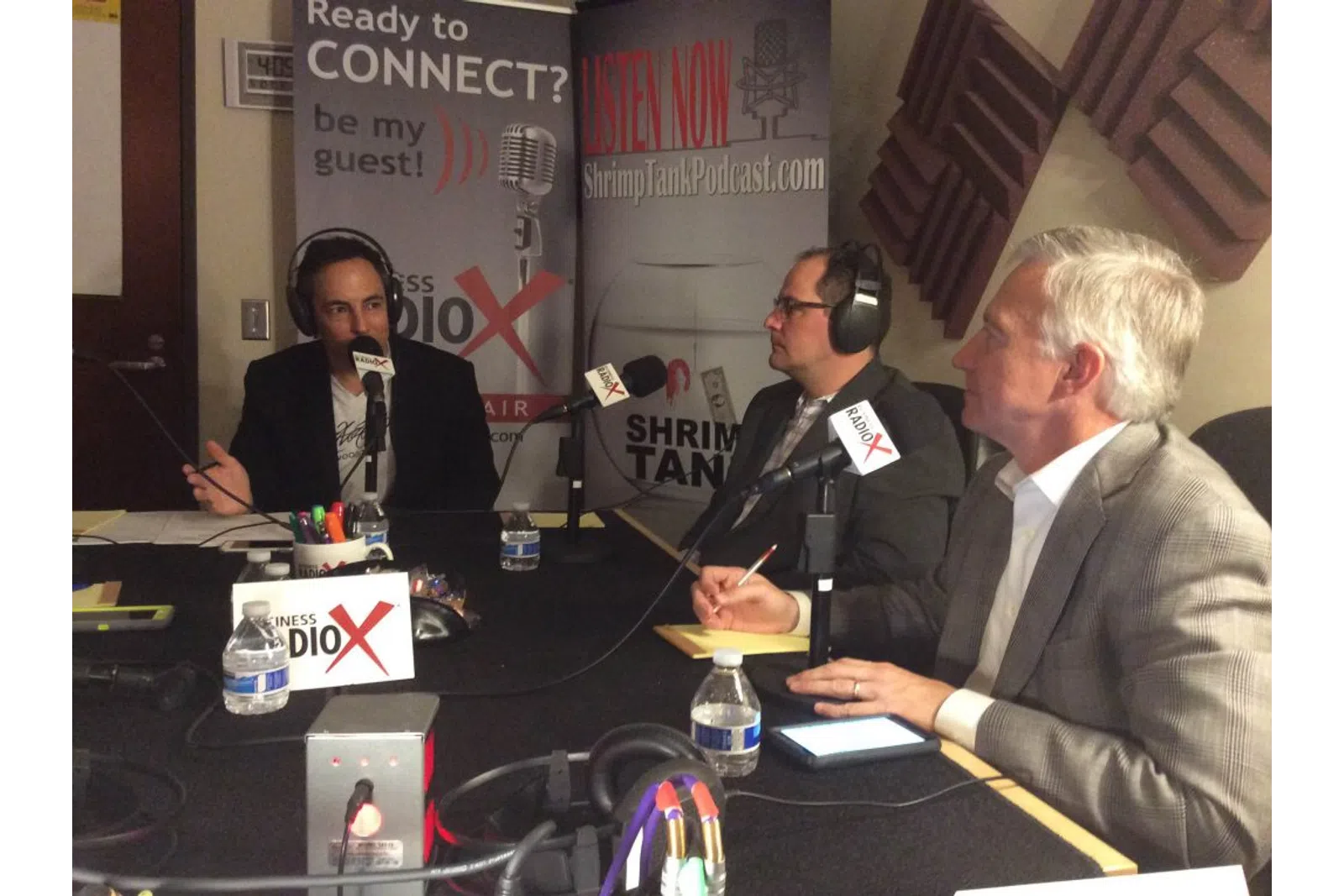 a group of people sitting at a table with microphones