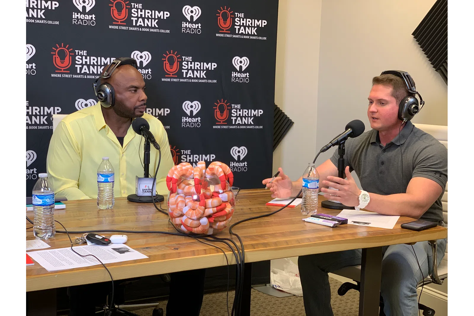 Toney Freeman et al. wearing headphones and sitting at a table with microphones