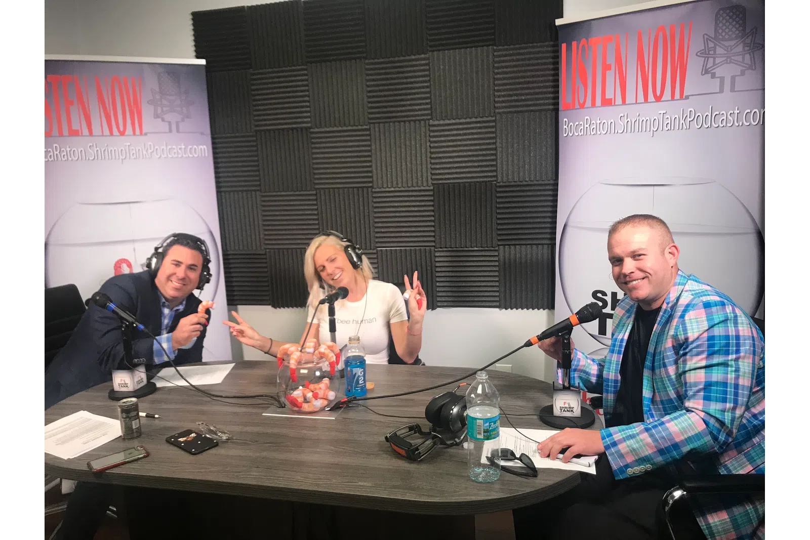 a group of people sitting at a table with microphones