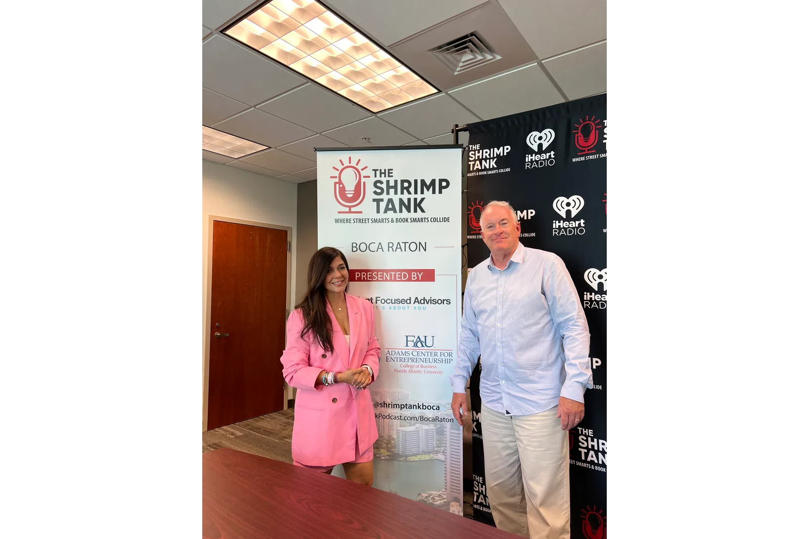 a man and a woman standing in front of a sign