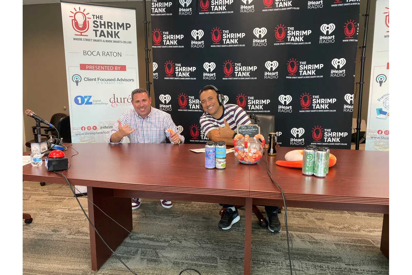 a couple of men sitting at a table with drinks and food