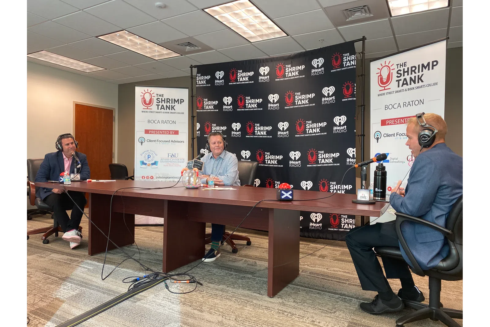 a group of people sitting at a table with microphones