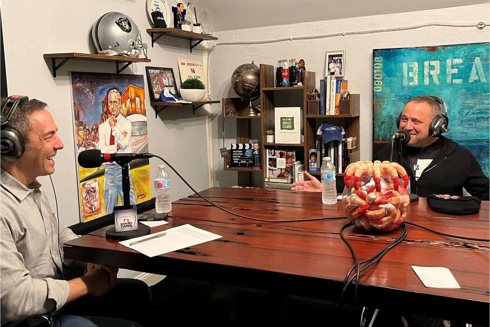 a couple of men wearing headphones and sitting at a table