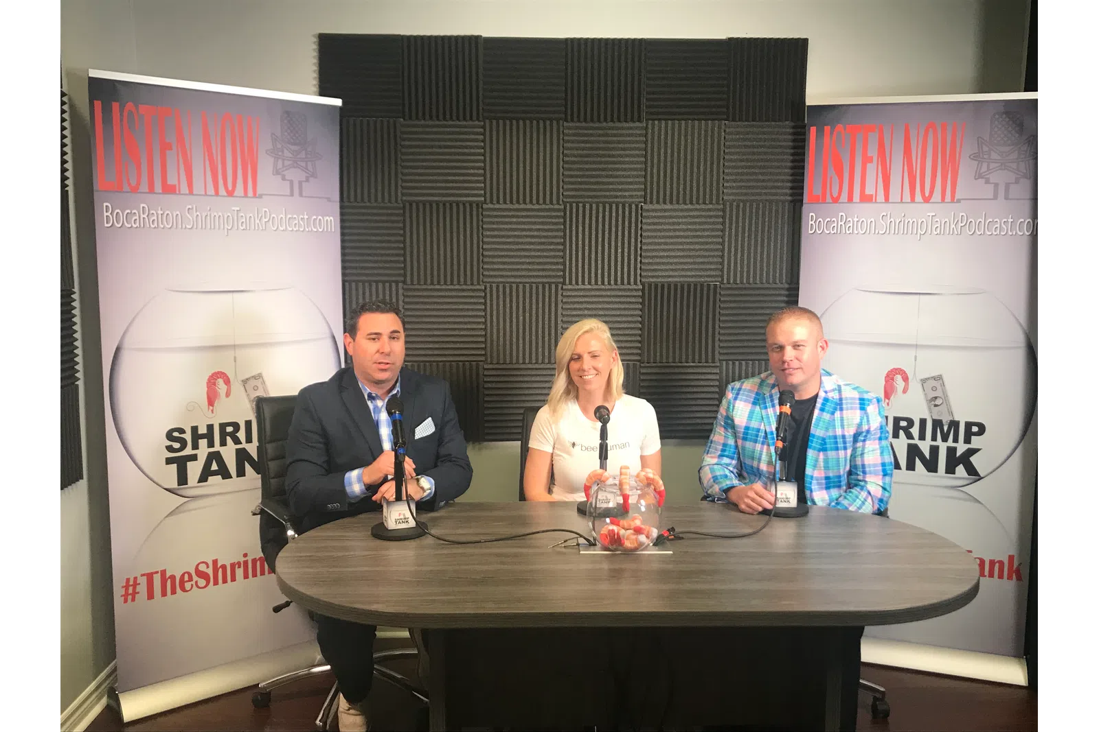a group of people sitting at a table with microphones