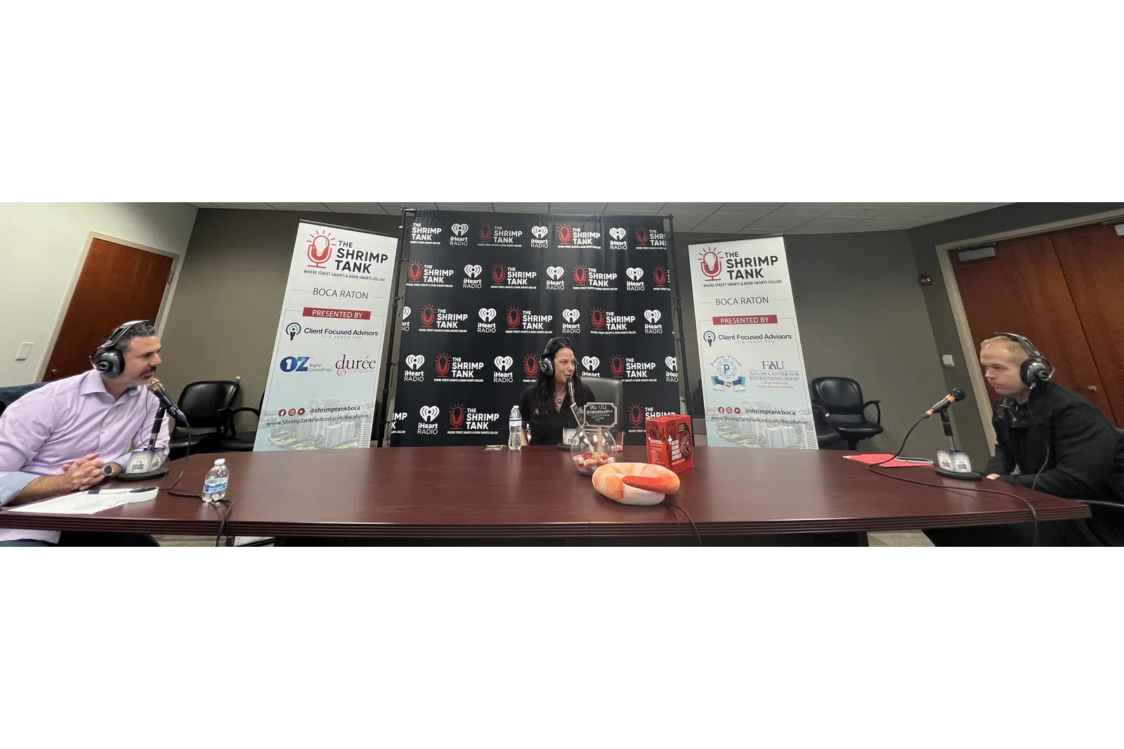 a group of people sitting at a table with microphones