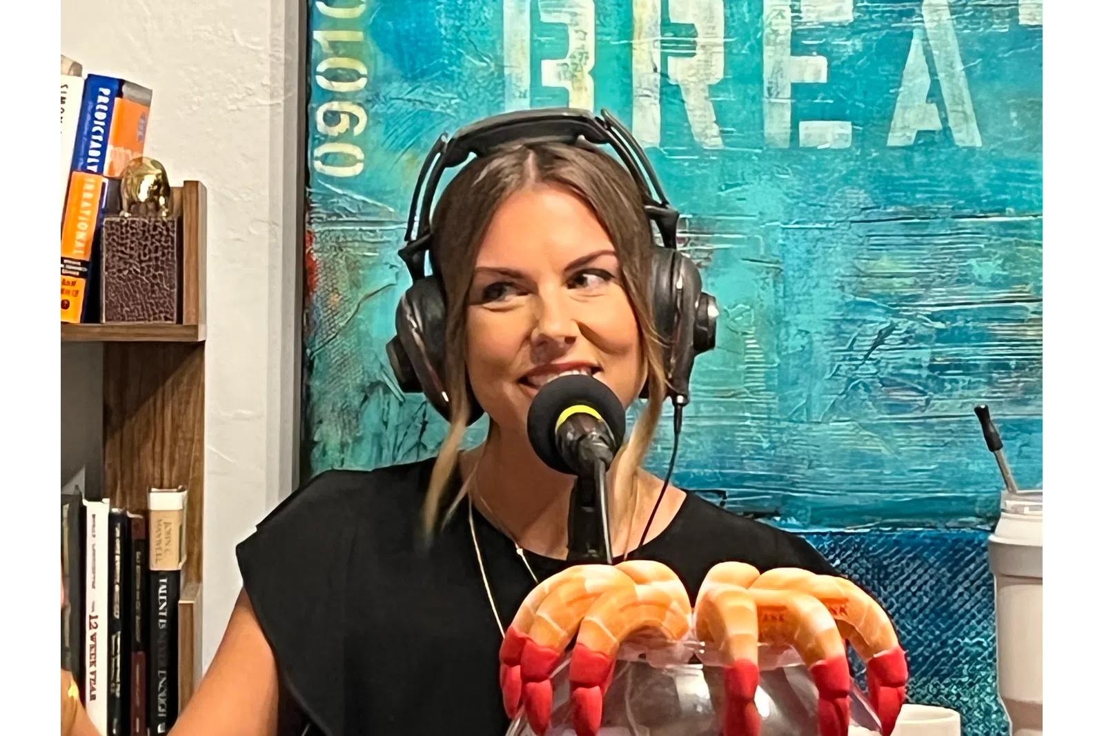 a woman wearing headphones and holding a drink
